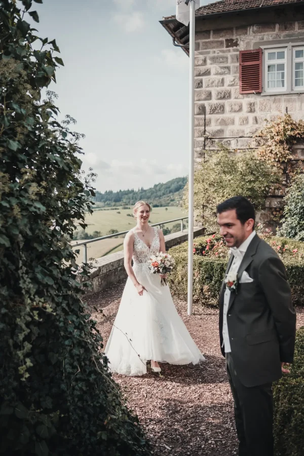 Der Bräutigam wartet geduldig auf seine Braut in der malerischen Umgebung der Burg Reichenberg. Die herbstliche Szenerie und das strahlende Lächeln verstärken die Vorfreude auf den besonderen Moment