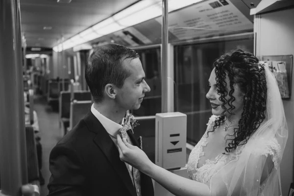 Hochzeitspaar teilt einen intimen Moment in der U-Bahn – kunstvolle Schwarz-Weiß-Aufnahme mit romantischer Atmosphäre.