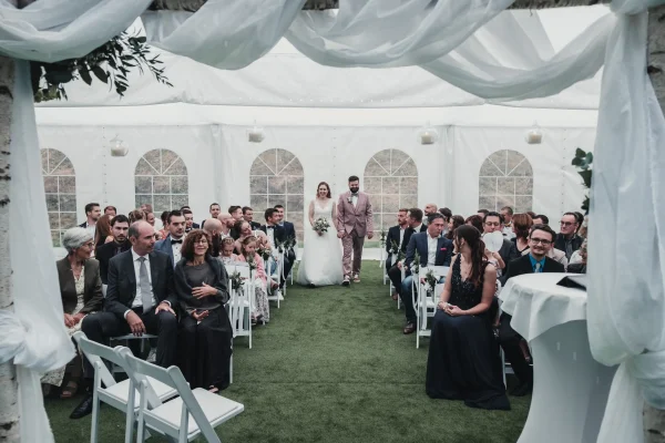 Brautpaar betritt gemeinsam das Festzelt, umgeben von ihren Gästen