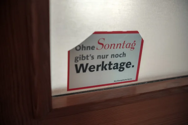 Detailaufnahme eines Schildes mit der Aufschrift „Ohne Sonntag gibt’s nur noch Werktage.“ in der Mauritiuskirche Mötzingen.