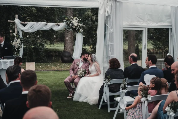 Romantischer Kussmoment des Brautpaares während der Zeremonie