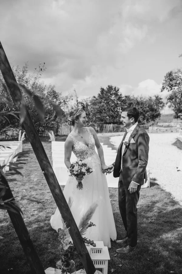 Das Paar lacht und genießt einen lockeren Moment auf dem Gelände von Lana Salta. Die ländliche Szenerie bildet eine perfekte Kulisse für dieses ungestellte, glückliche Paarshooting.