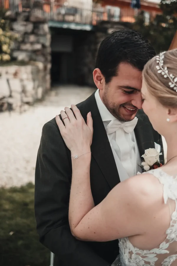 Die Braut legt die Hand mit ihrem Ehering auf die Schulter des Bräutigams.