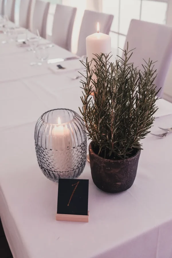 Elegante Hochzeitsdekoration mit weißen Stühlen und stilvollen Tischarrangements