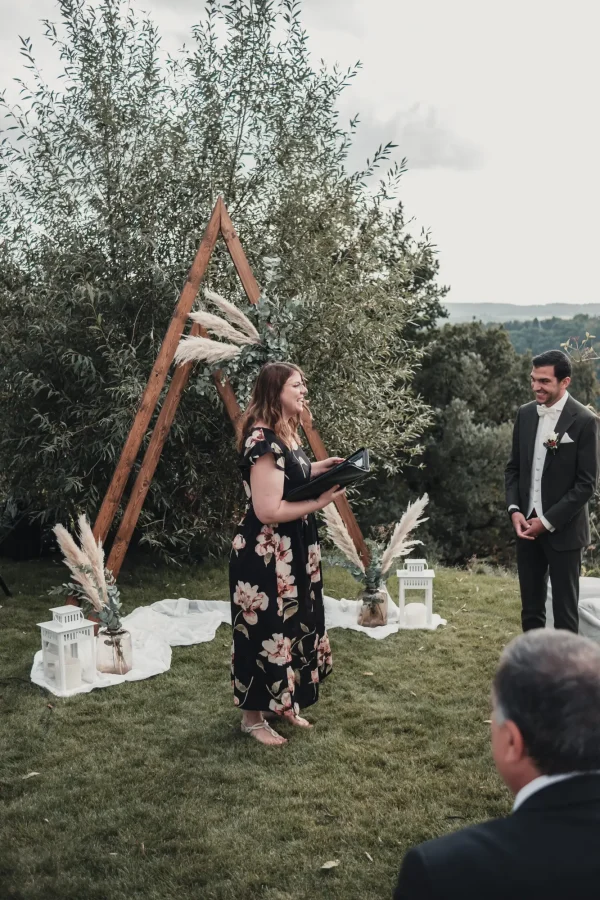 Die freie Traurednerin Jasmin von 100 Dinge an dir, spricht mit einem Lächeln zur Hochzeitsgesellschaft vor dem dekorativen Traubogen im Lana Salta.