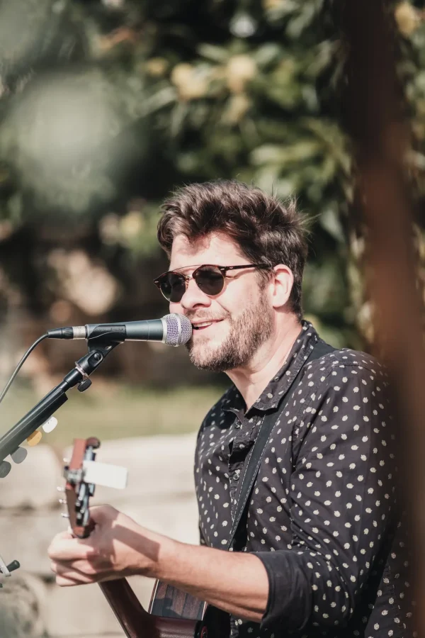 Wolfgang Morenz, der Musiker der freien Trauung, singt mit seiner Gitarre und verbreitet eine emotionale Stimmung unter den Gästen.