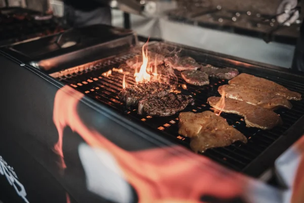 Detailaufnahme des Grillguts. Flammen schießen aus dem Gasgrill.