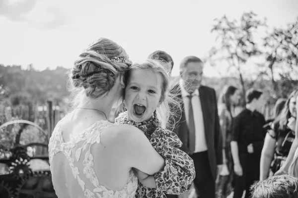 Ein lachendes Kind auf dem Arm der Braut bei den Gratulationen