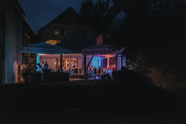 Außenansicht der Pfrondorfer Mühle am Abend mit festlich beleuchtetem Zelt und gemütlicher Atmosphäre.