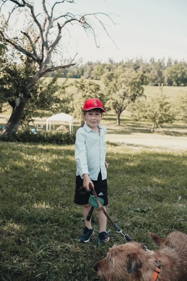 Kind mit Hund an der Leine.