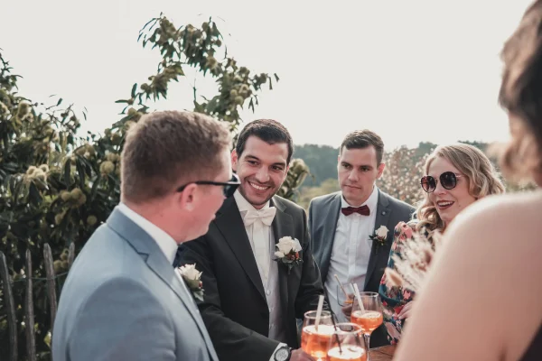 Der Bräutigam inmitten seiner Gäste am Stehtisch, Gespräche