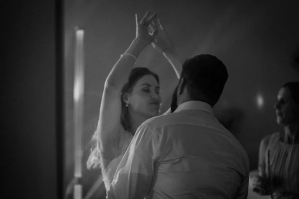 Schwarz-Weiß-Aufnahme eines tanzenden Brautpaares in stimmungsvoller Party-Atmosphäre.