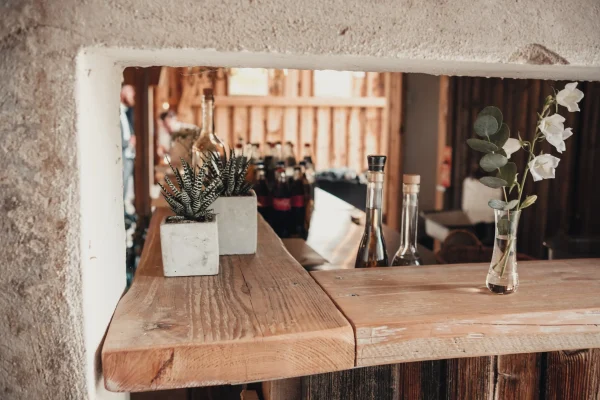 Dekoration in der Festscheune. Altholzbalken als Regalbretter und Blumendekoration.