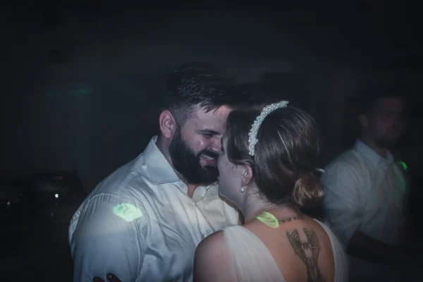 Braut und Bräutigam lächeln sich beim Tanz verliebt an.