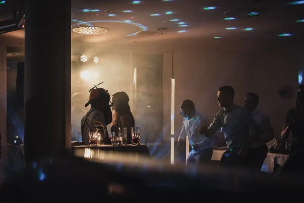 Gruppenfoto der Hochzeitsgesellschaft beim Feiern.Tanzende Gäste. Propeller Mütze