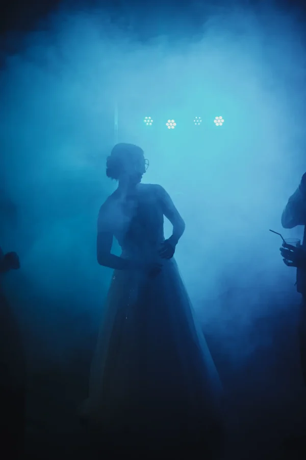 Tanzende Braut auf der Tanzfläche bei Nebel und gedämpften blauen Licht